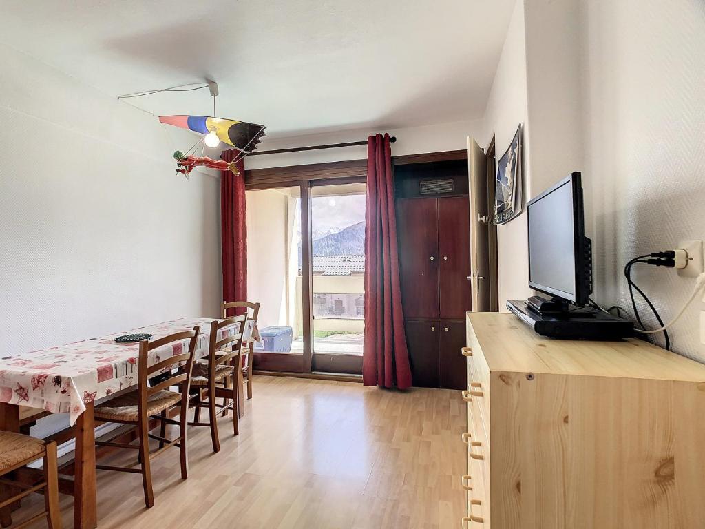 un salon avec une table à manger et une télévision dans l'établissement Appartement cosy 4 pers, balcon sud, proche pistes et commerces - FR-1-417-74, à La Toussuire