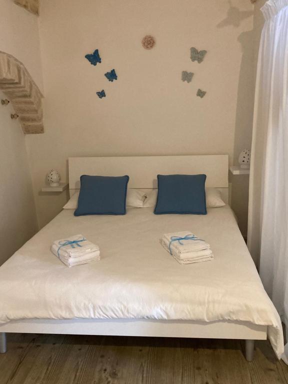 ein Schlafzimmer mit einem Bett mit blauen Kissen darauf in der Unterkunft La casa di Alessia Largo Torre in Noci