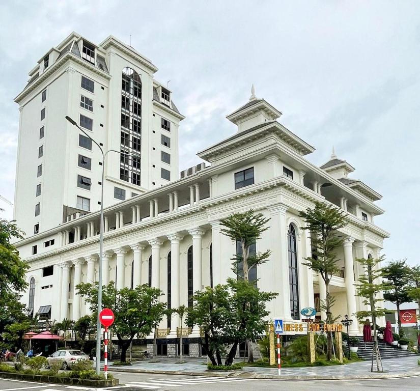 a large white building with a tall building at Thiên Ân Hotel in Thôn Dương Phẩm