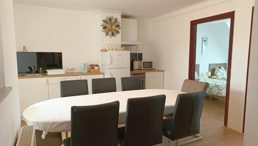 a kitchen and dining room with a table and chairs at HOKE lakás in Sopron