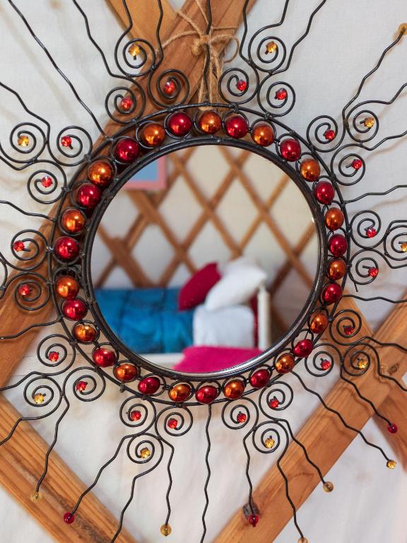 a mirror on a wall with a bed in a room at Yourtissimo in Laprugne