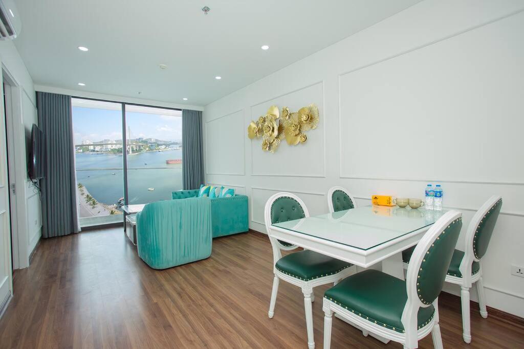 een eetkamer met een tafel en stoelen met uitzicht bij Green Diamond Luxury Apartment 15A11 in Ha Long