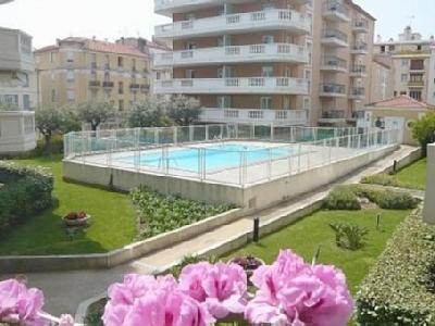 une vue sur une piscine et quelques fleurs roses dans l'établissement Palais Des Dômes 718, à Nice