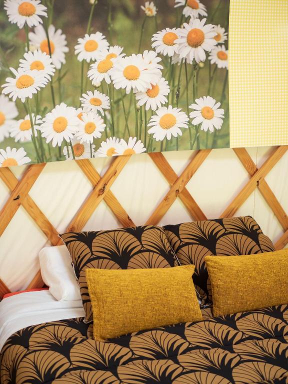 a room with a couch with white flowers on the wall at Yourtissimo in Laprugne