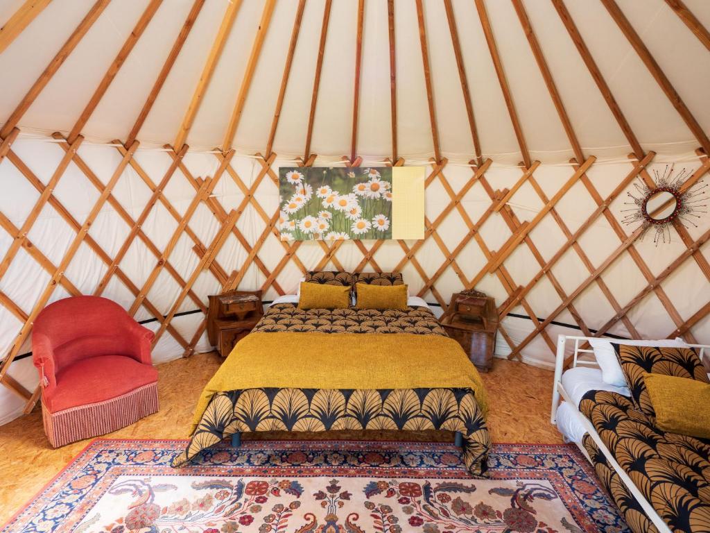 a bedroom with a bed in a yurt at Yourtissimo in Laprugne