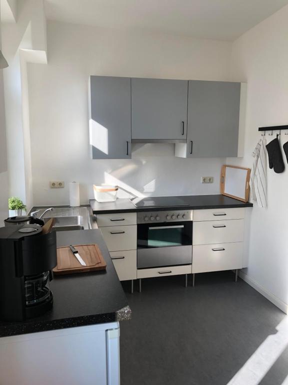 a kitchen with white cabinets and a black counter top at In der Mühlenstraße in Malchow