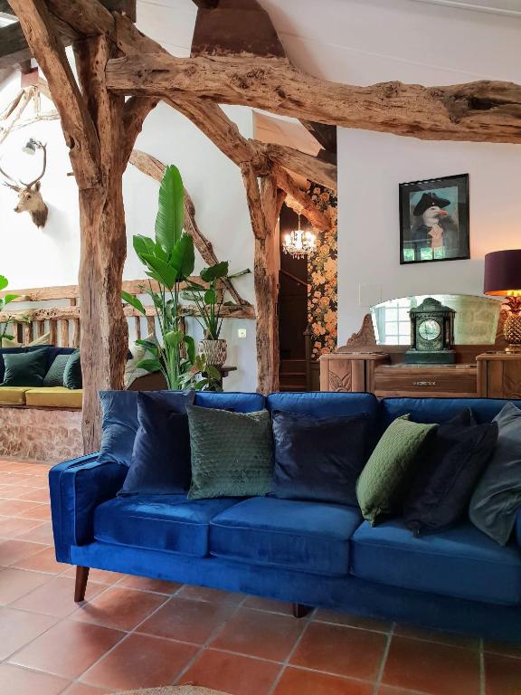- un canapé bleu dans un salon avec des plafonds en bois dans l'établissement Rusty Shears46 Eclectic couples escape, hot tub & Cahors vineyards, à Lacapelle-Cabanac