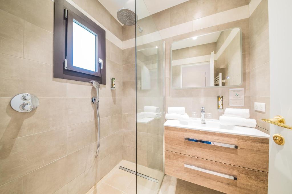 a bathroom with a glass shower and a sink at Hotel Brin d'Azur - Saint Tropez in Saint-Tropez