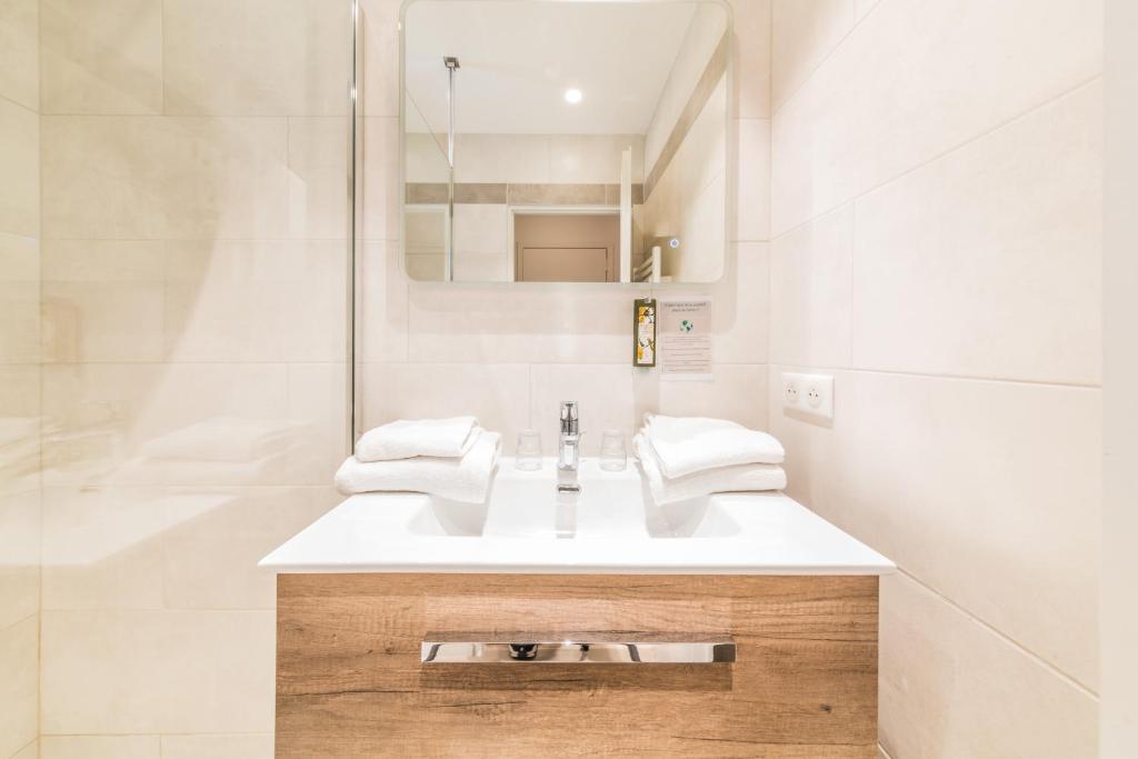 a white bathroom with a sink and a mirror at Hotel Brin d'Azur - Saint Tropez in Saint-Tropez