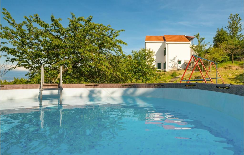 a swimming pool with a seesaw and a playground at Beautiful Apartment In Veprinac With Wifi in Veprinac