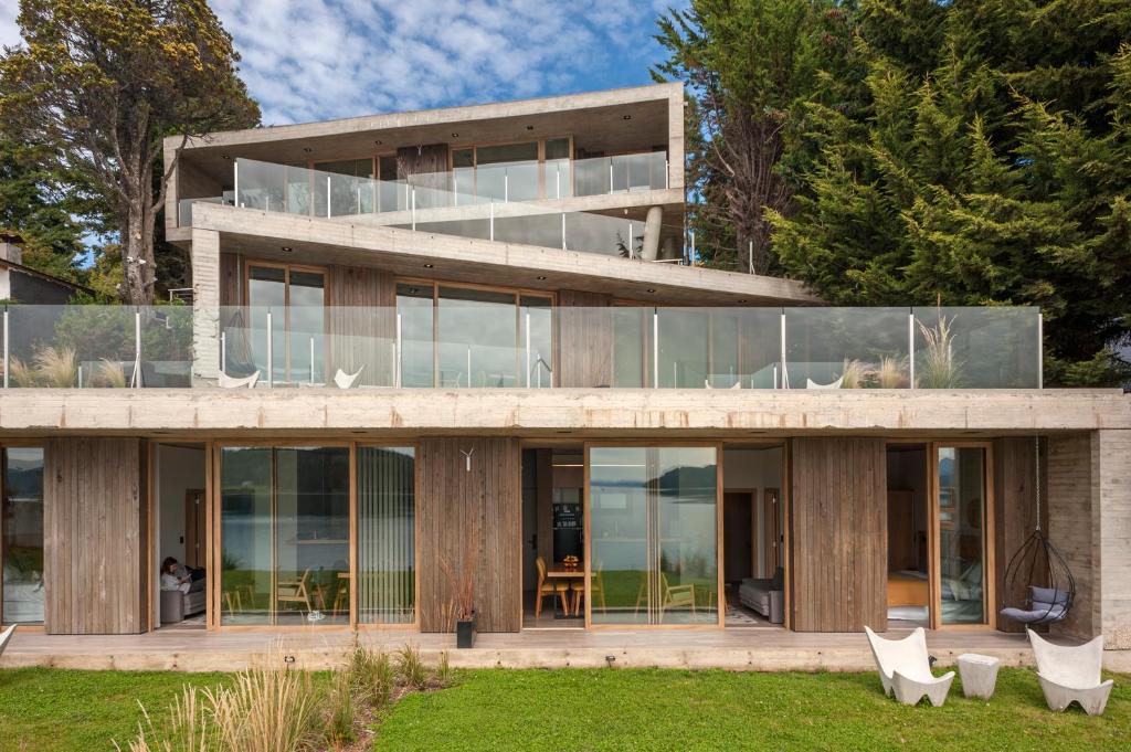 uma casa com portas de vidro e um quintal em Wa One Lake Homes em San Carlos de Bariloche