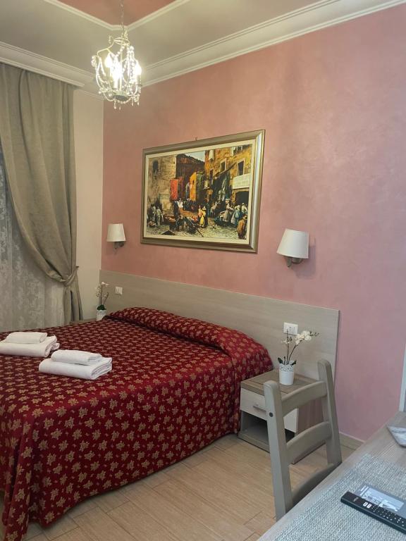 a bedroom with a red bed and a painting on the wall at Bye Rome Guesthouse in Rome