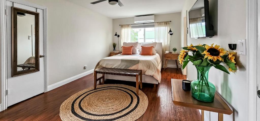 a bedroom with a bed and a vase of flowers on a table at Studio Mins to Culver City Downtown, Sony & Venice in Los Angeles