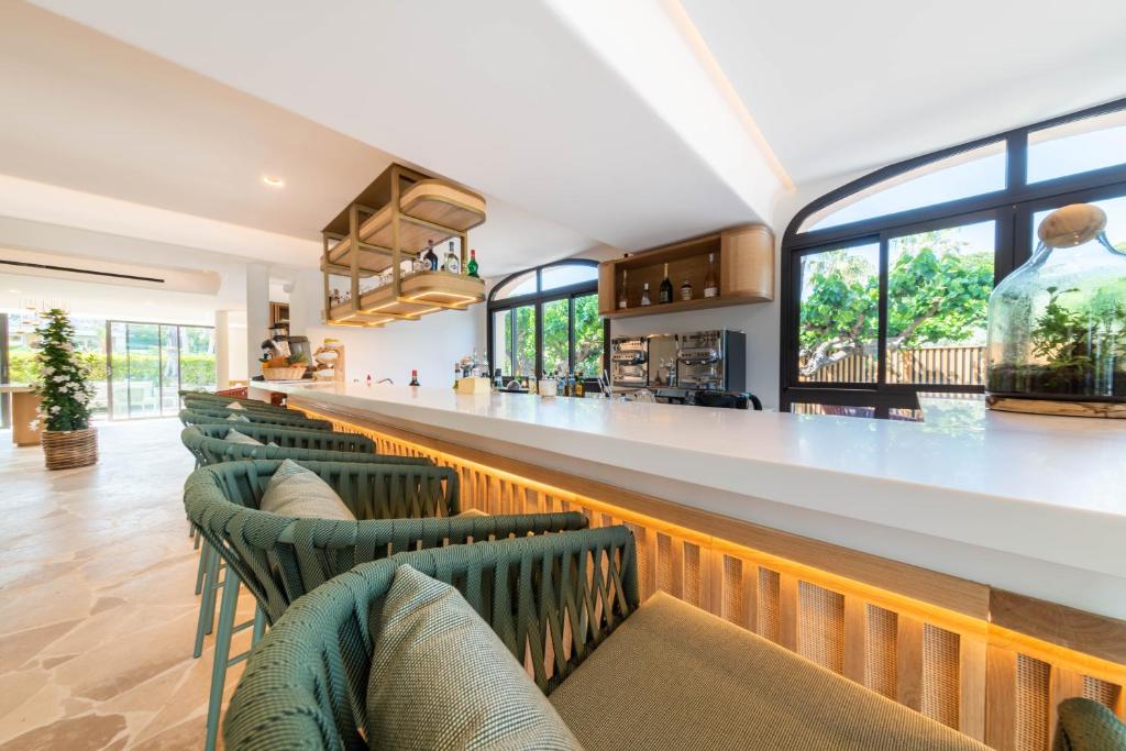 a bar with green chairs in a restaurant at Hotel Brin d'Azur - Saint Tropez in Saint-Tropez