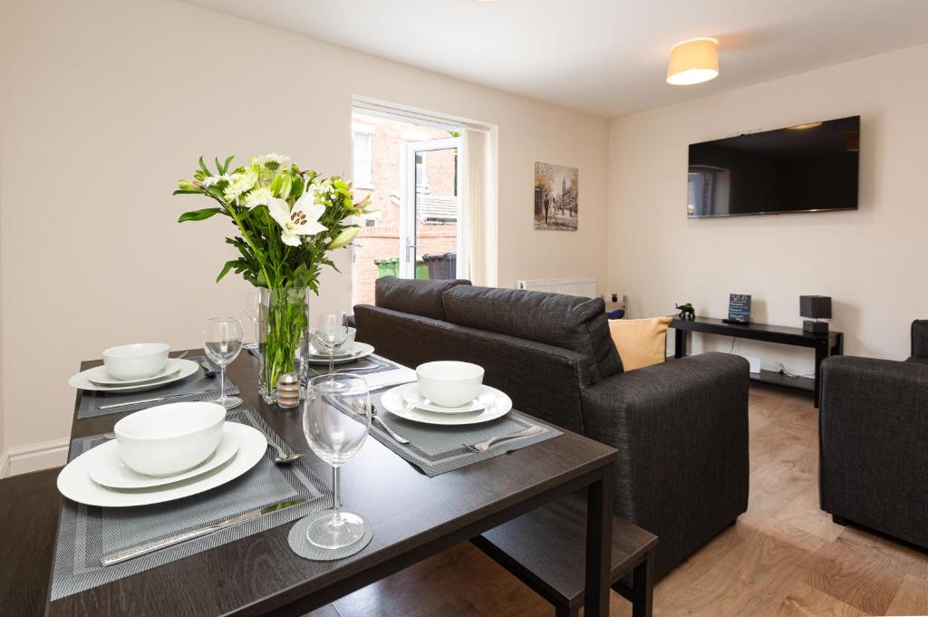 a living room with a dining room table with flowers on it at Oxheys House - 5 Bedrooms Contractors Parking in Preston