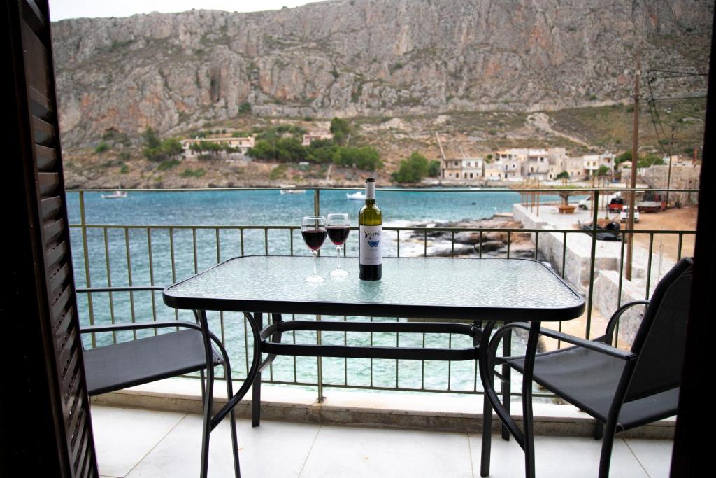 una mesa con 2 copas de vino en el balcón en Gerolimin Blue, en Yerolimin