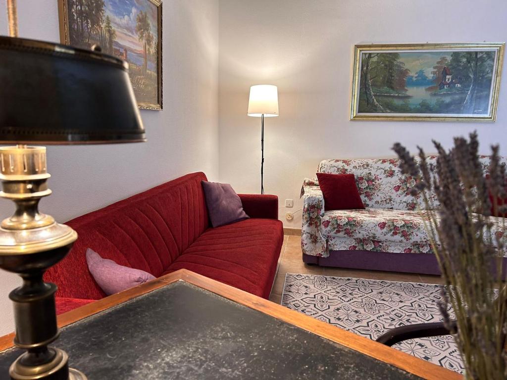 ein Wohnzimmer mit einem roten Sofa und einem Stuhl in der Unterkunft Apulia appartament in Taranto