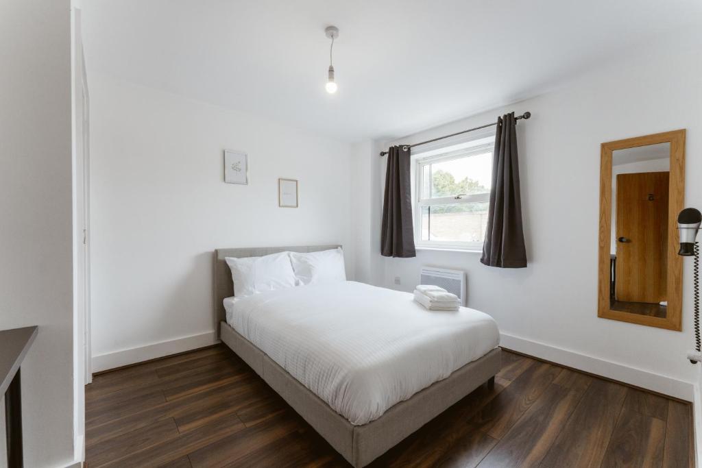 a white bedroom with a bed and a window at LimeHouse Double Rooms - 3 in London