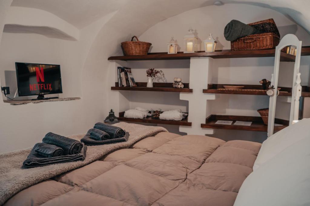 ein Schlafzimmer mit einem Bett mit Kissen darauf in der Unterkunft Rustico con SPA Privata - Piscina - Sauna - Hammam - Free Wi-Fi & NETFLIX in Brossasco