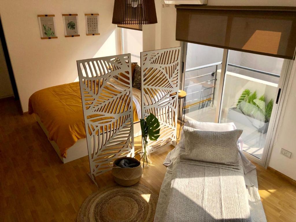 Un dormitorio con una cama y una silla y una ventana. en Hermoso estudio amoblado con cochera MOVISTAR ARENA, en Buenos Aires