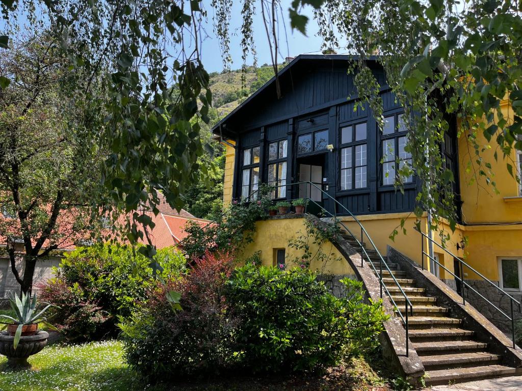 a yellow and black house with stairs leading up to it at ApartmentVillaSolomon7 in Visegrád