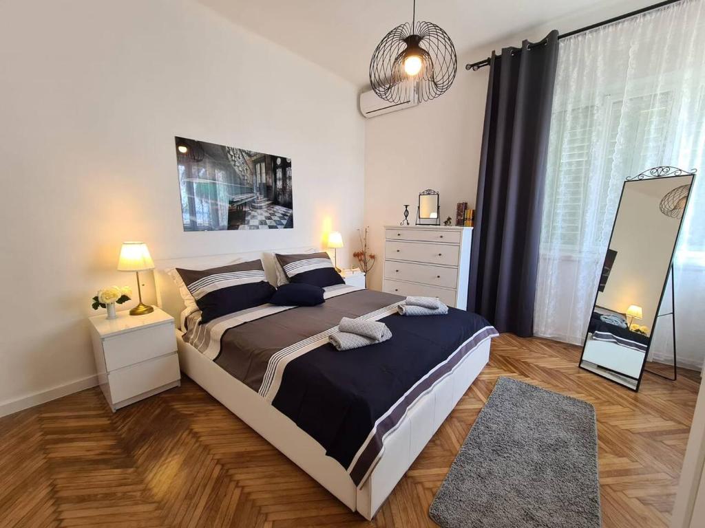 a bedroom with a large bed and a mirror at Luxury apartment Lukas in Orebić