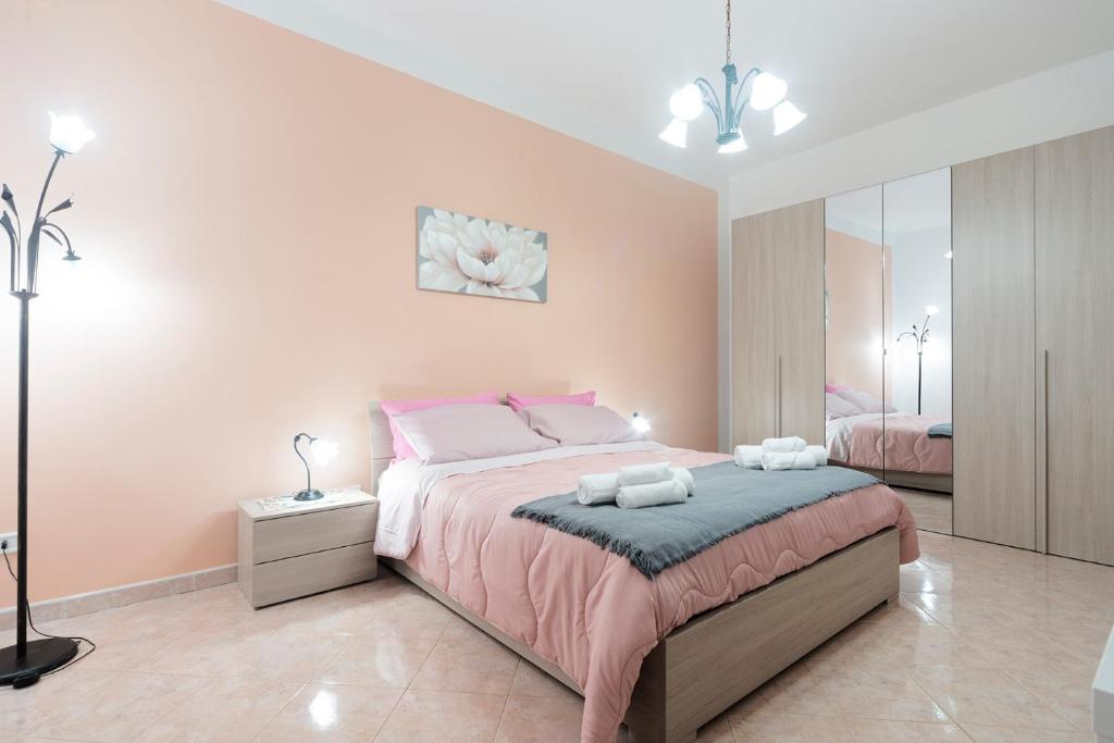 1 dormitorio con 1 cama grande y paredes de color rosa en Nina Home - Selfcheck-in, en Canicattini Bagni