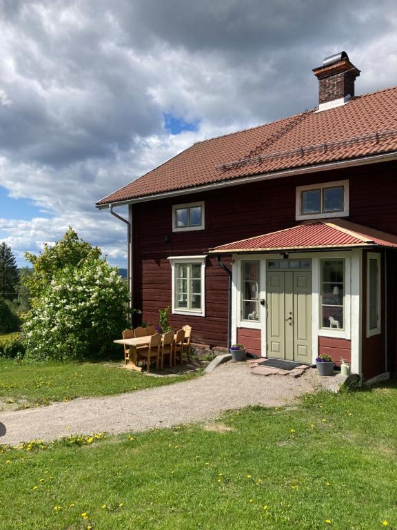 een huis met een tafel en een bank ervoor bij Proselinsgården in Bjursås