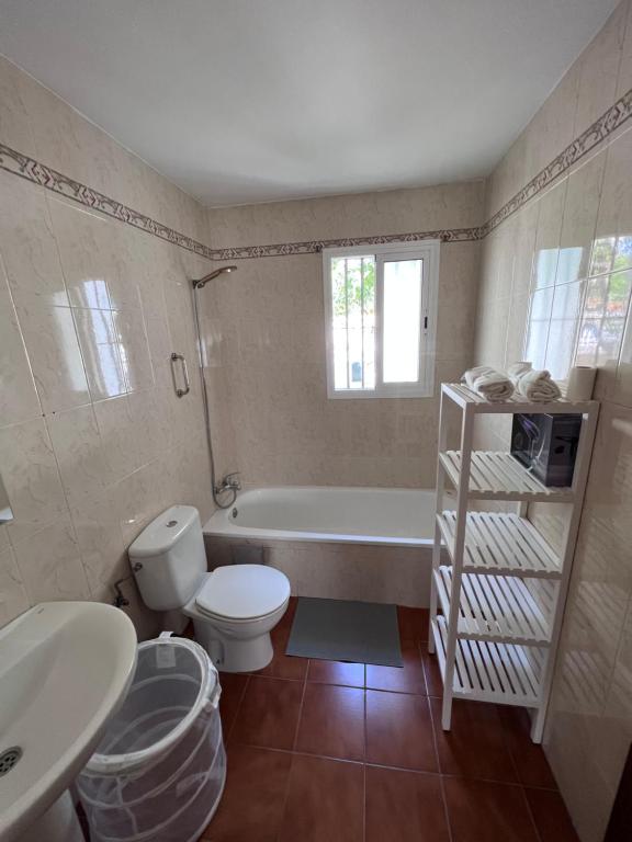 Un baño con bañera, inodoro y lavabo. en Casa de Fernando, en Puerto Real