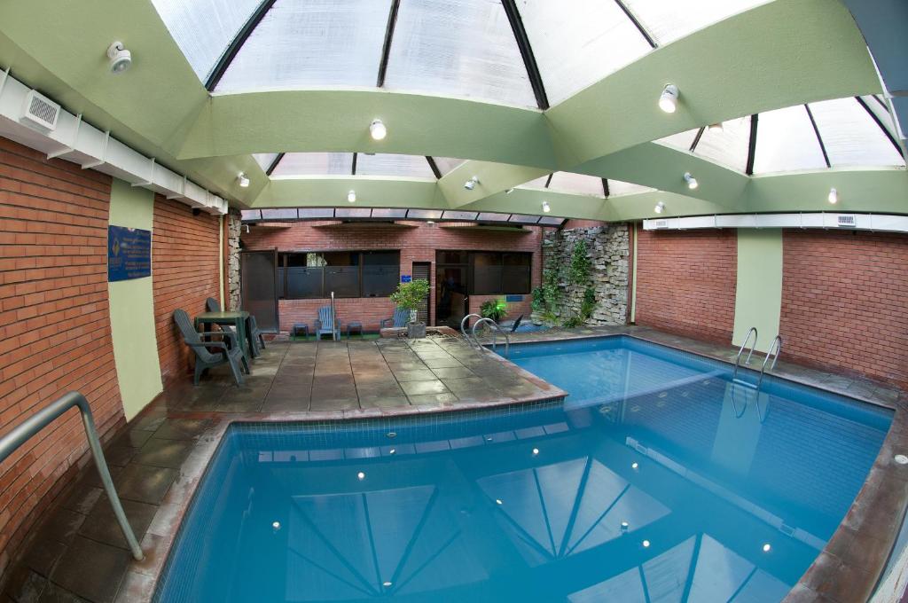 an indoor swimming pool with a large glass ceiling at Primacy Apart Hotel in Mar del Plata