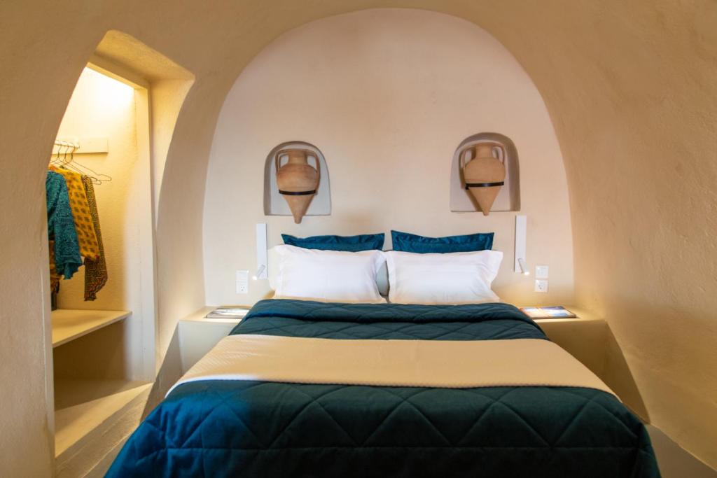 a bedroom with a large bed in a room at Amphora Villas Oia Santorini in Foinikiá