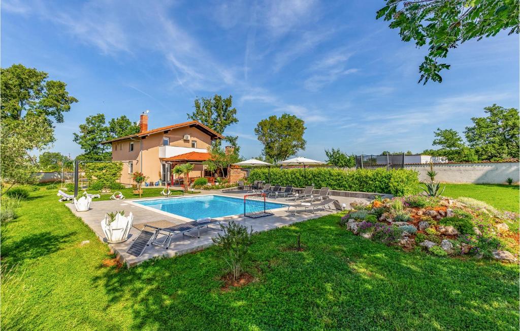 une arrière-cour avec une piscine et une maison dans l'établissement 4 Bedroom Cozy Home In Marcana, à Marčana