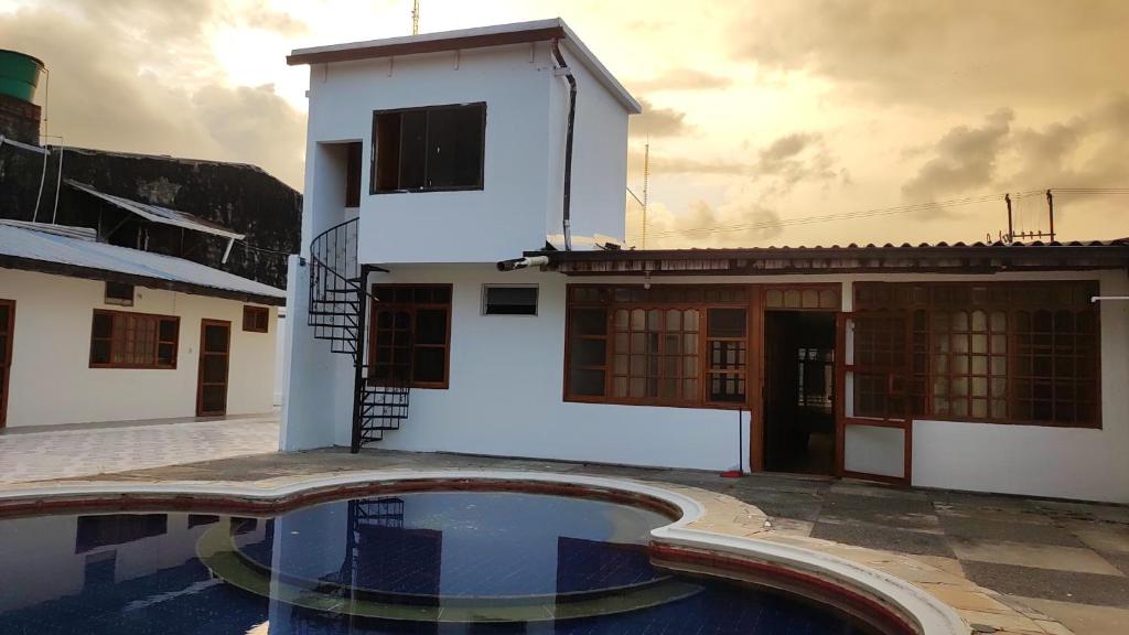 a house with a pool in front of a building at LETICIAS GUEST HOUSE in Leticia