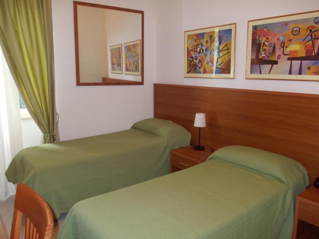 a room with two green beds and a mirror at Hotel Solaria in Rodi Garganico