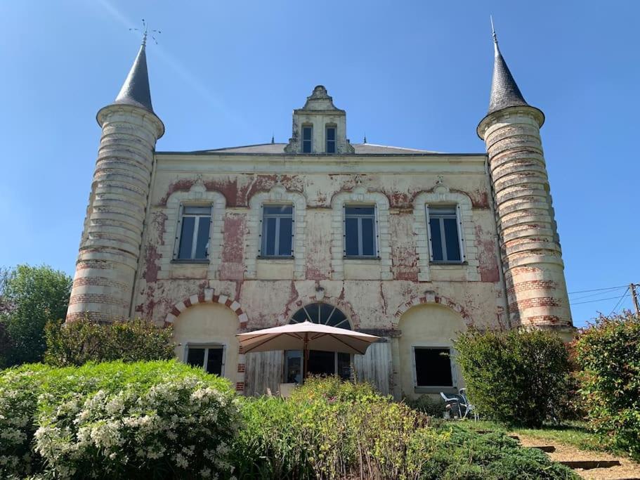 un antiguo edificio con dos torres encima en Le château rouge, en Écommoy