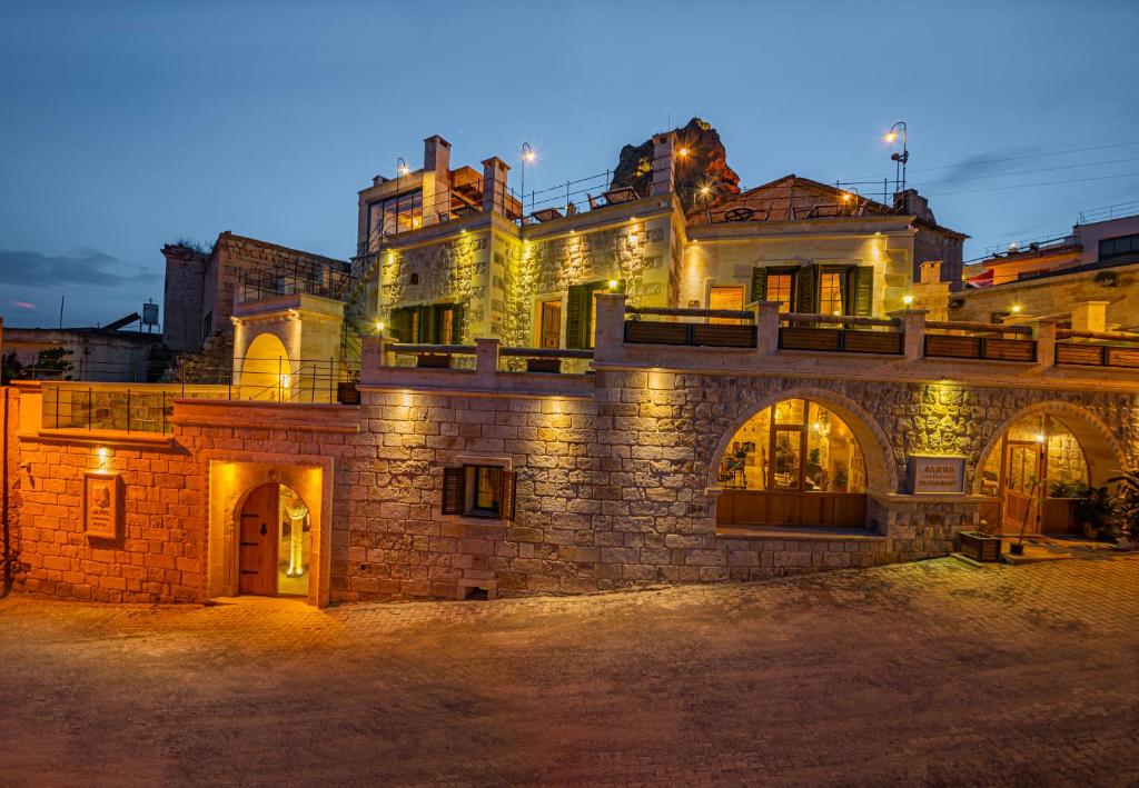 a stone building with lights on it at night at Janus Cappadocia Hotel in Nevsehir