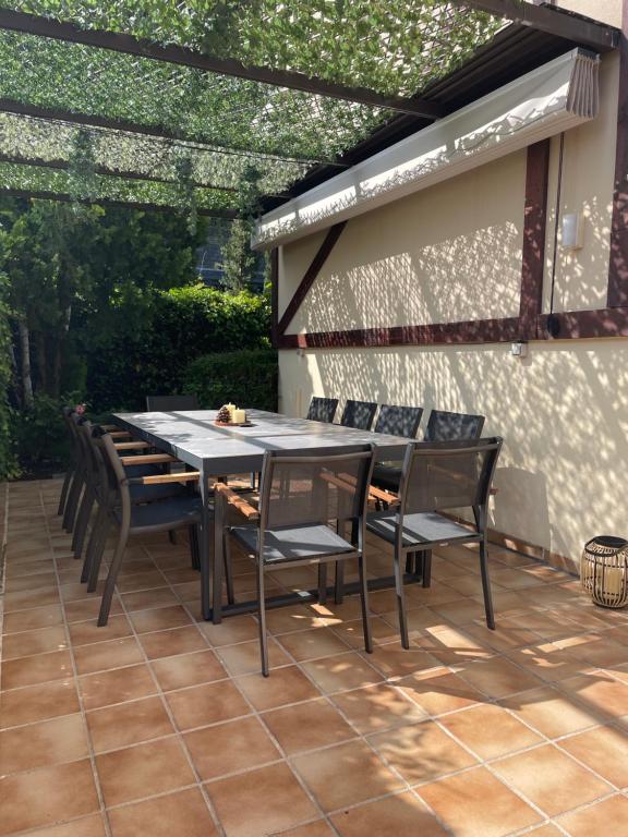 un patio con mesa y sillas bajo una pérgola en Moderna Casa de Lujo con Jardín y Barbacoa en Madrid