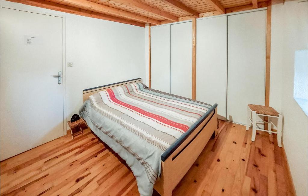 a bed in a room with a wooden floor at Amazing Home In Essertines-en-chtelne With 3 Bedrooms in Essertines-en-Châtelneuf
