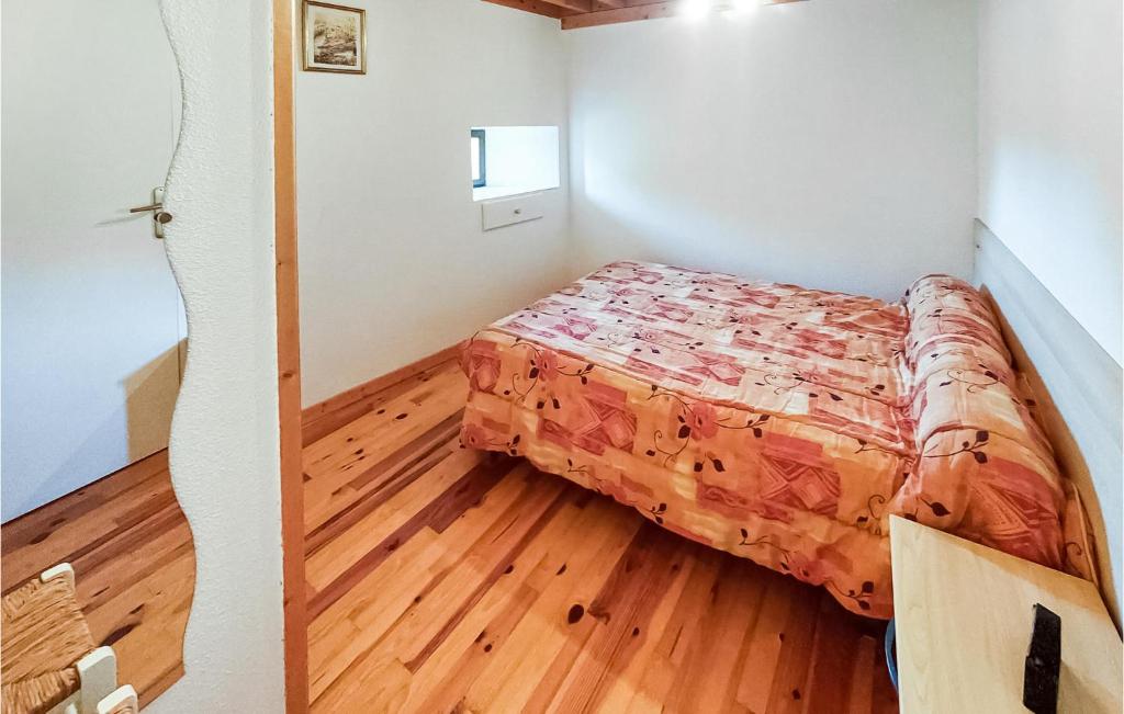a small bedroom with a bed and a wooden floor at Amazing Home In Essertines-en-chtelne With 3 Bedrooms in Essertines-en-Châtelneuf
