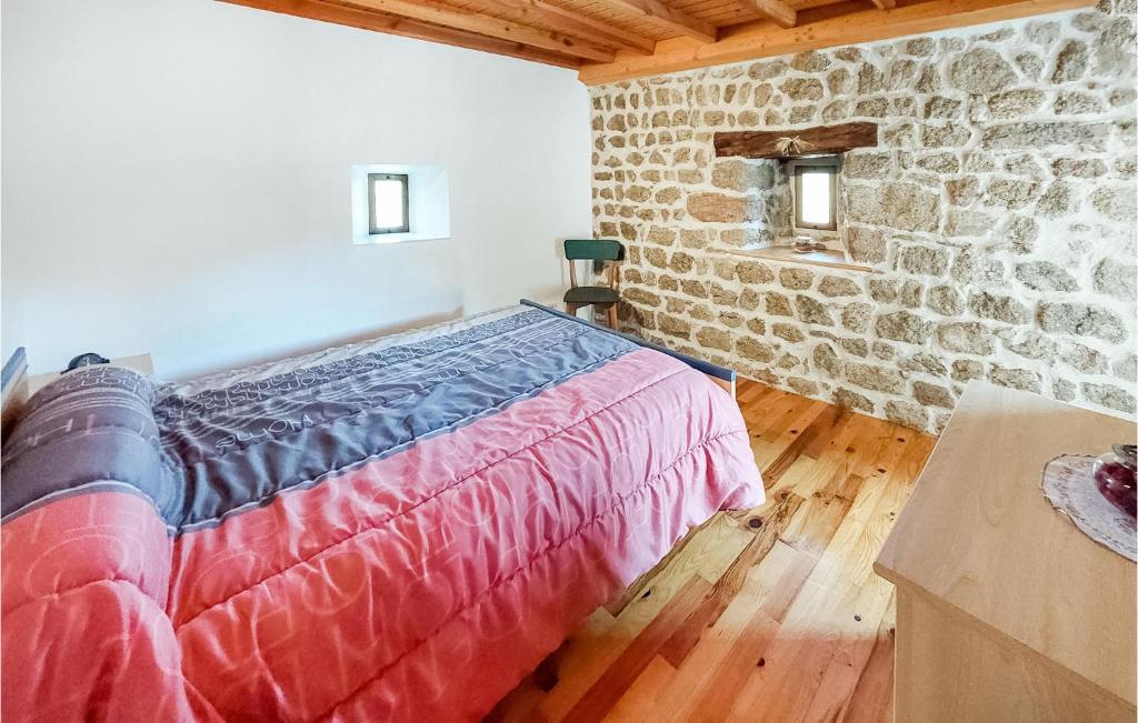 a bedroom with a bed and a stone wall at Amazing Home In Essertines-en-chtelne With 3 Bedrooms in Essertines-en-Châtelneuf