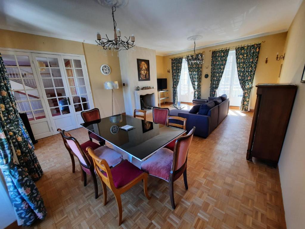 un soggiorno con tavolo, sedie e divano di Maison de caractère / Petit Versailles Normand a Valognes