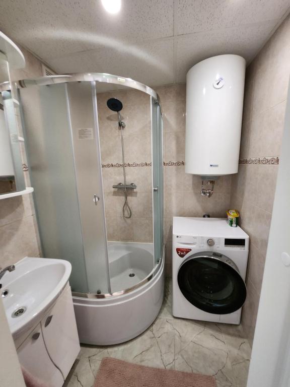 mała łazienka z prysznicem i pralką w obiekcie Hubane 3-toaline korter Roiul 