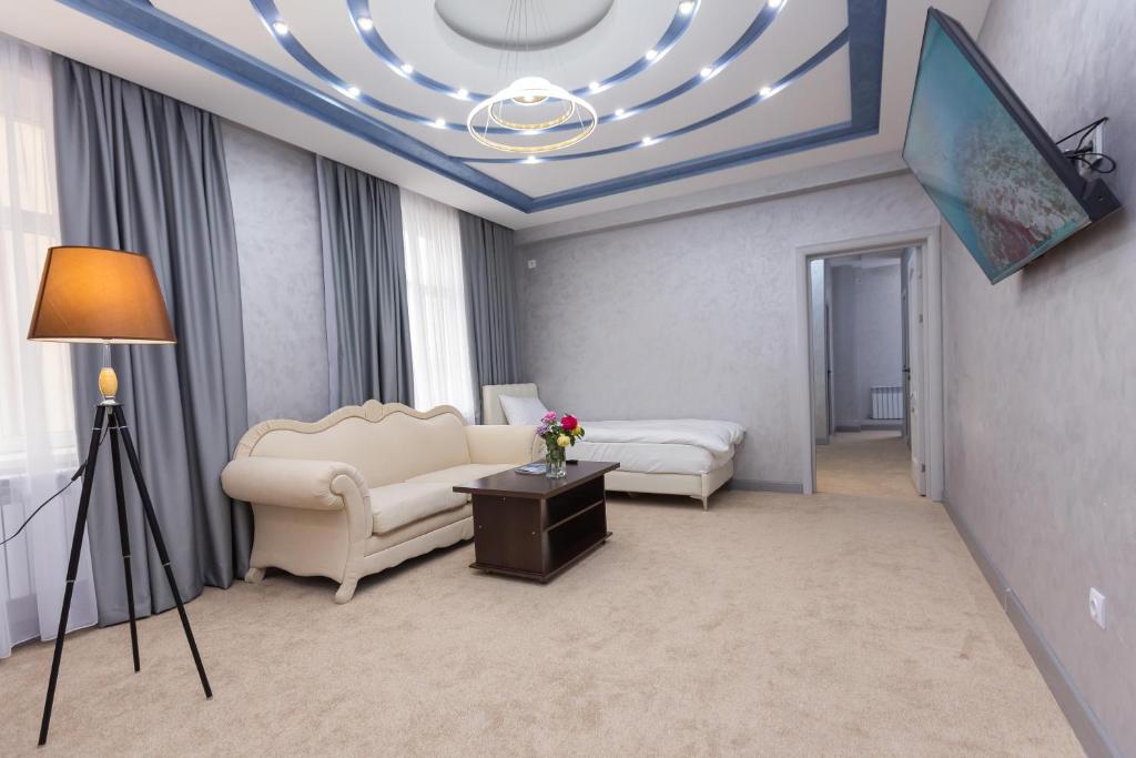 - un salon avec un canapé et une table dans l'établissement Amelia Hotel, à Almaty