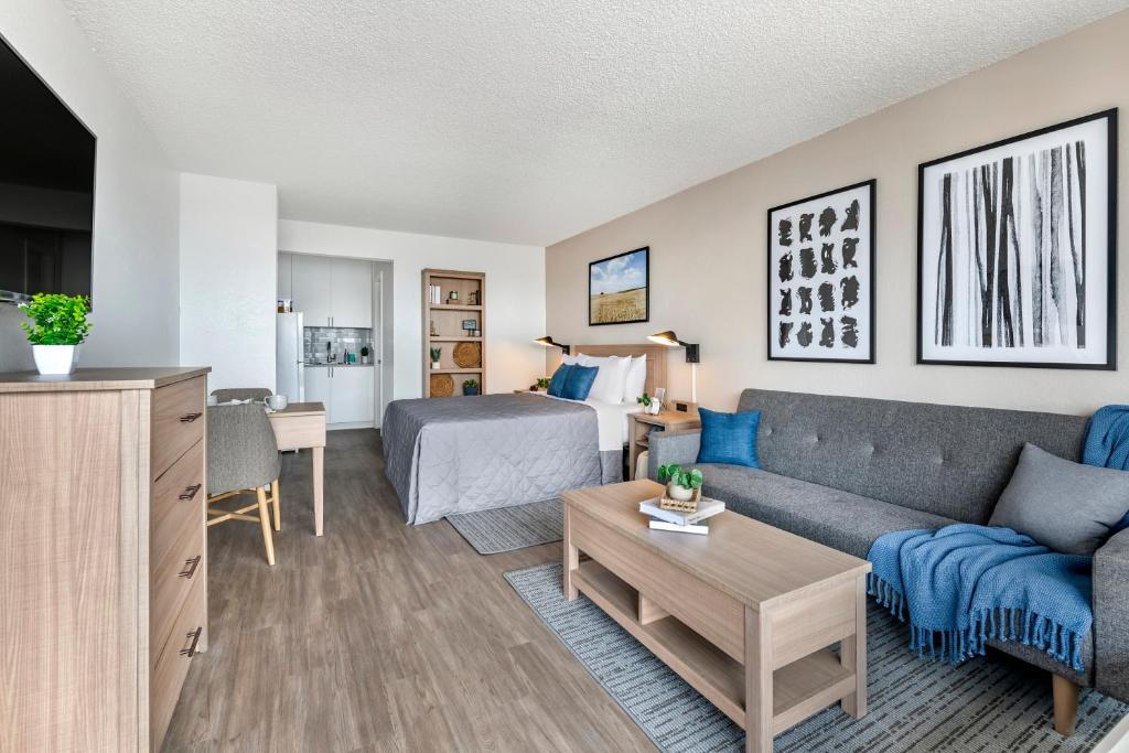 sala de estar con sofá y cama en InTown Suites Extended Stay Select Orlando FL - Lee Rd, en Orlando