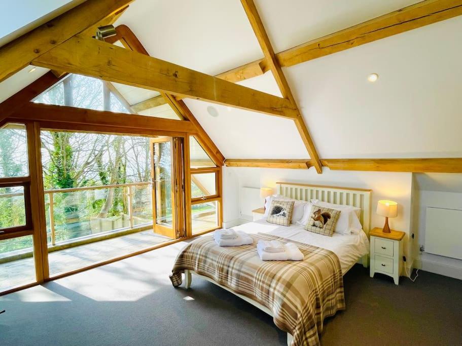 a bedroom with a bed and a large window at Woodland View Stunning Spacious 5 Bedroom Holiday Home in Saint Lawrence