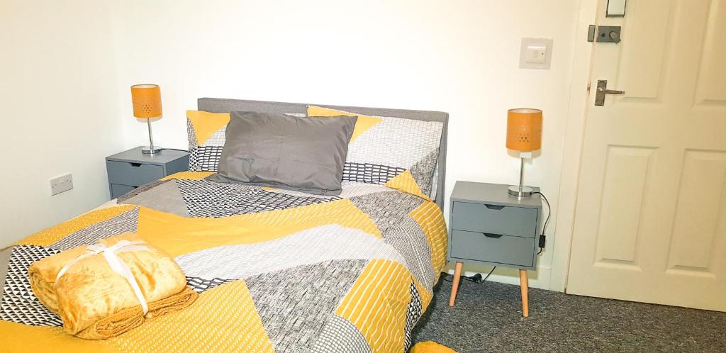 una camera con un letto e due comodini con lampade di Kunda House Bearwood a Birmingham