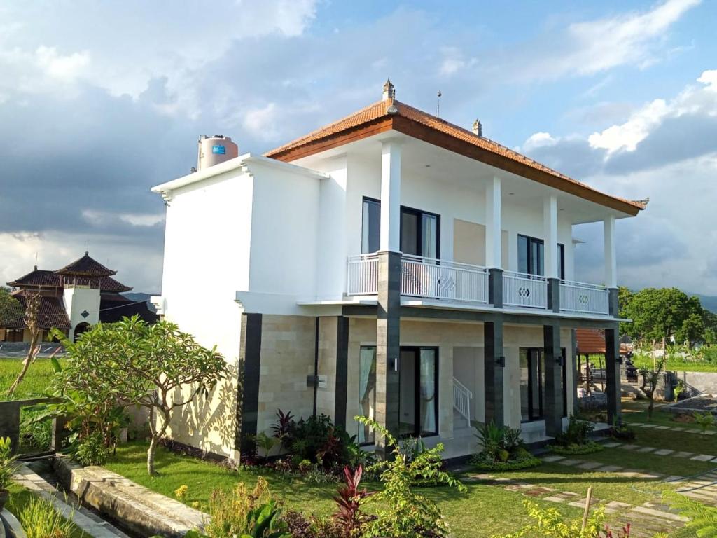 Casa blanca con balcón en Limun guesthouse, en Ujung