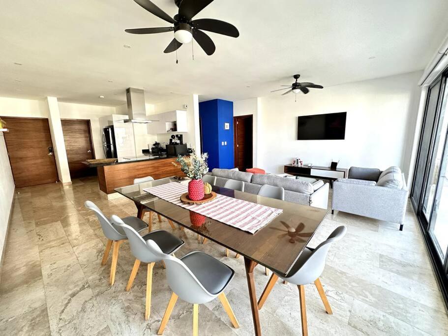 a dining table and chairs in a living room at New Condo with Pool, Gym, A/C, WiFi, King Size bed in Cancún