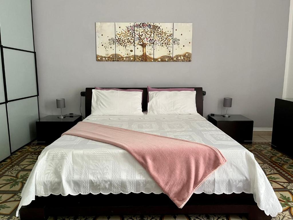 una camera da letto con un letto con una coperta rosa sopra di Alsimica Apartment a Taranto