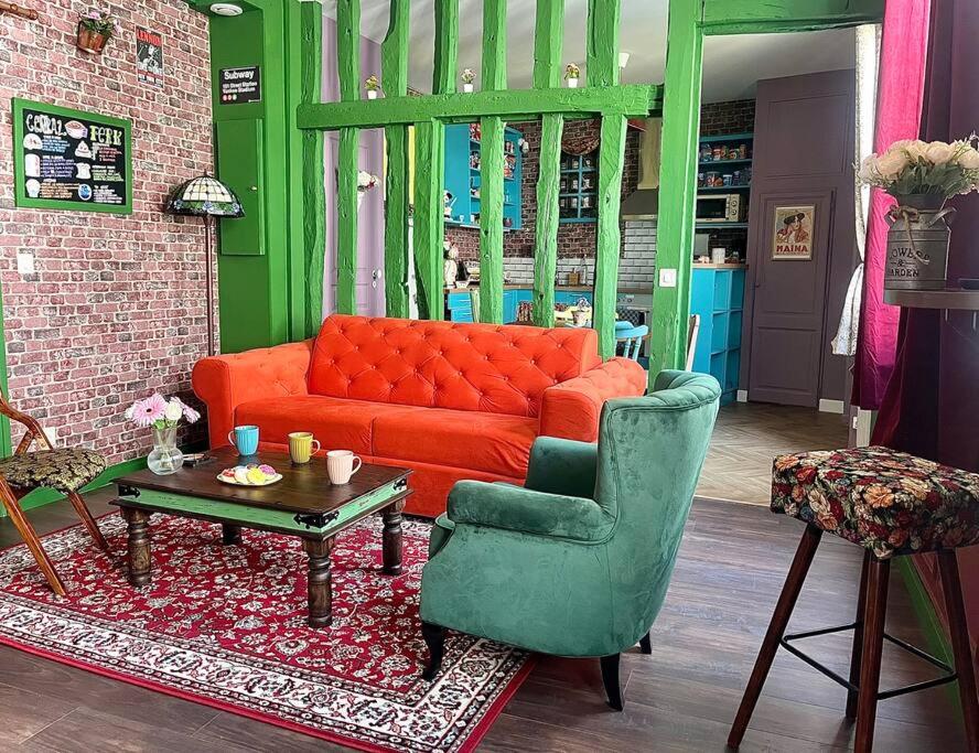 - un salon avec un canapé orange et une chaise dans l'établissement Appartement Friends, à Rouen